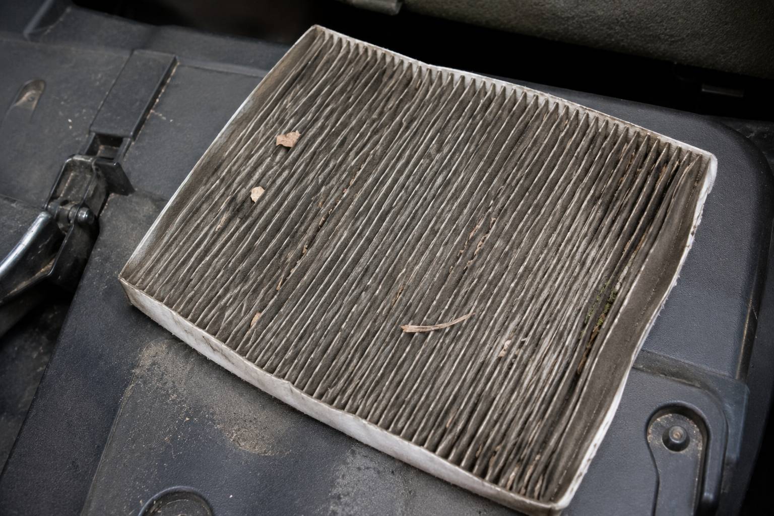 A heavily contaminated cabin air filter traps moisture and produces a foul odor..